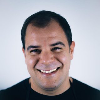 Max, smiling, in a black apron